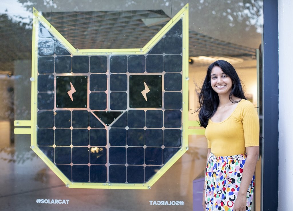 Founder Krystal Persaud stands next to her SolarCat installation Solarcat